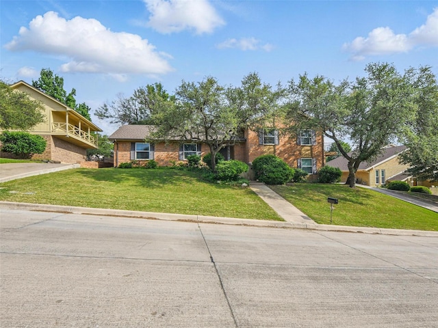 traditional-style home with brick siding and a front lawn