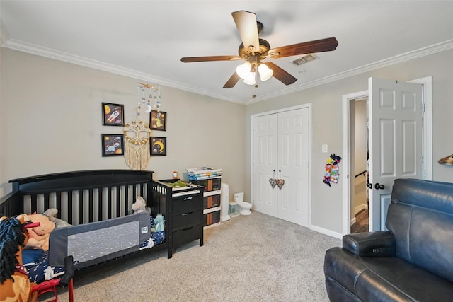 carpeted bedroom with a ceiling fan, baseboards, visible vents, ornamental molding, and a closet