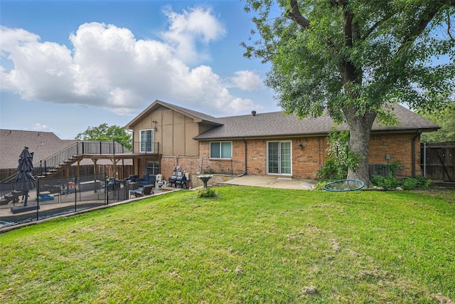 back of house with a patio, a fenced backyard, brick siding, a shingled roof, and a yard