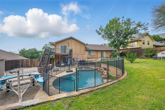 view of swimming pool with a lawn, a patio area, stairway, a fenced in pool, and a fenced backyard