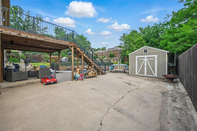 view of vehicle parking with a storage unit, a fenced backyard, and stairway