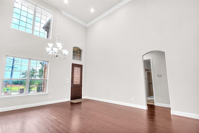 3020 Nyala Trl, Frisco, TX 75034 - entryway with dark wood-type flooring, arched walkways, crown molding, and a high ceiling