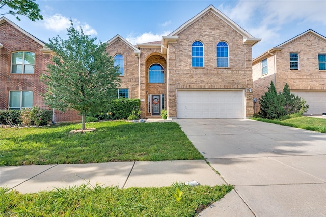 traditional home with concrete driveway, brick siding, an attached garage, and a front yard