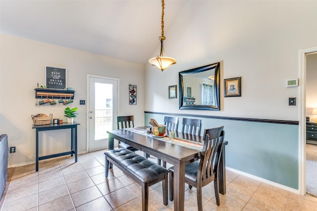 dining room featuring baseboards, light tile patterned floors, and high vaulted ceiling