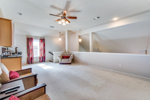 living area with ceiling fan, light carpet, and visible vents