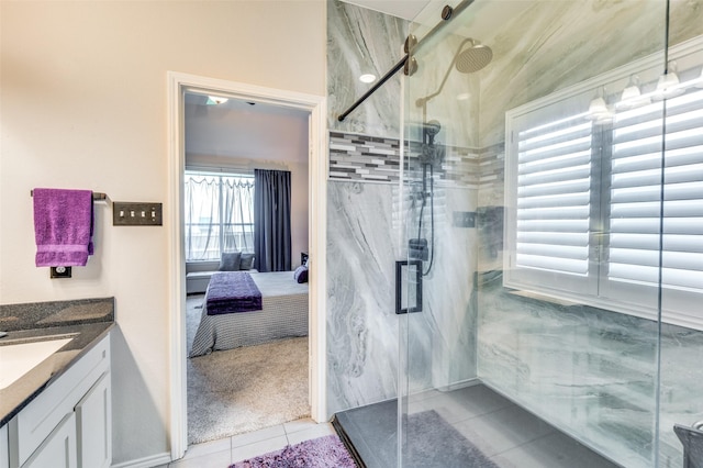 full bathroom with connected bathroom, a marble finish shower, tile patterned flooring, and vanity