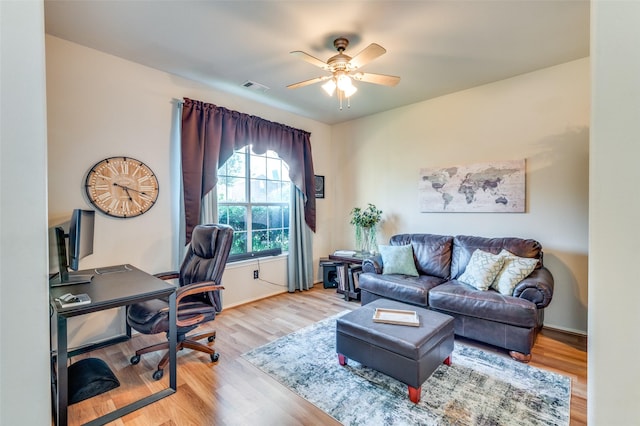 office space featuring a ceiling fan, baseboards, visible vents, and wood finished floors