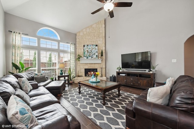 13283 Bodega Trl, Frisco, TX 75035 - living area featuring a ceiling fan, a stone fireplace, arched walkways, wood finished floors, and high vaulted ceiling