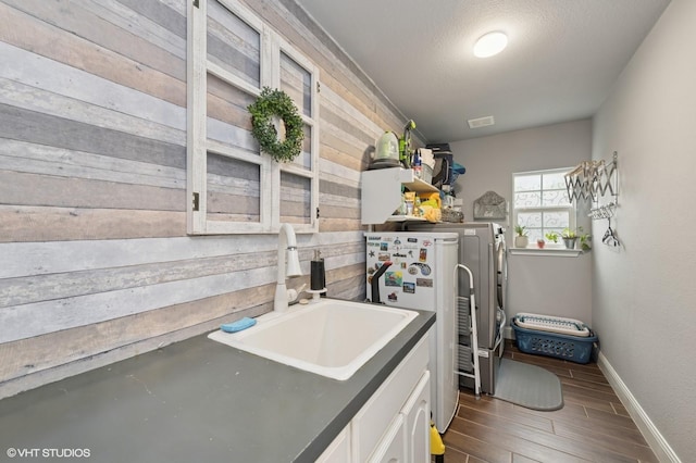 13283 Bodega Trl, Frisco, TX 75035 - washroom with laundry area, wood walls, a sink, baseboards, and separate washer and dryer