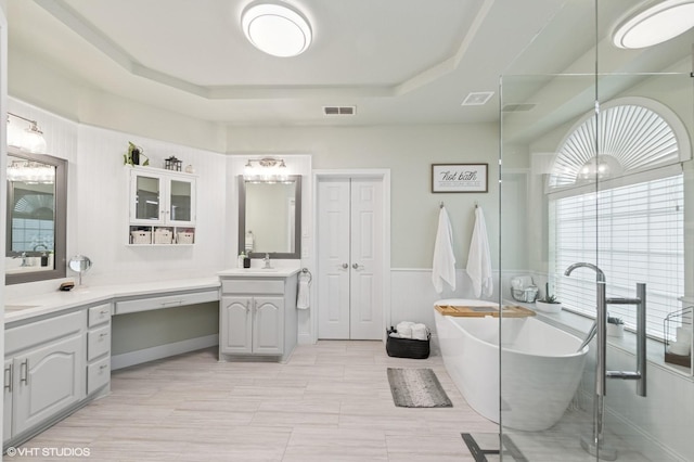 13283 Bodega Trl, Frisco, TX 75035 - bathroom with vanity, a raised ceiling, visible vents, and a soaking tub