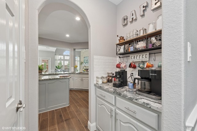13283 Bodega Trl, Frisco, TX 75035 - bar with a sink, arched walkways, recessed lighting, tasteful backsplash, and dark wood-style floors