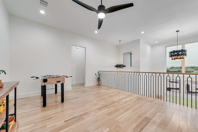 playroom featuring baseboards, ceiling fan with notable chandelier, wood finished floors, and visible vents