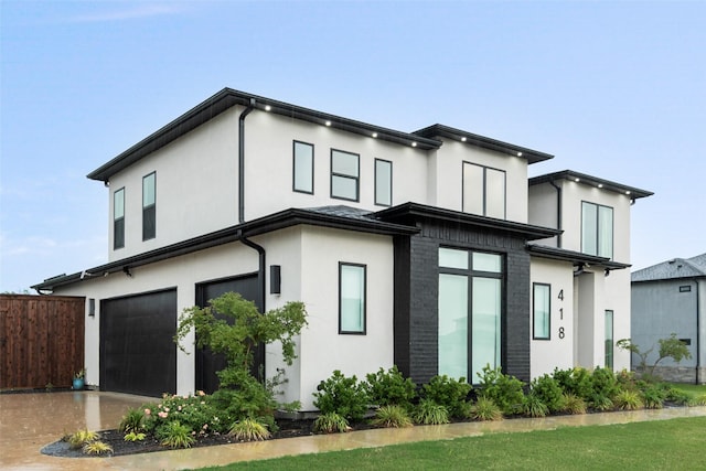 view of side of home with an attached garage, stucco siding, and fence