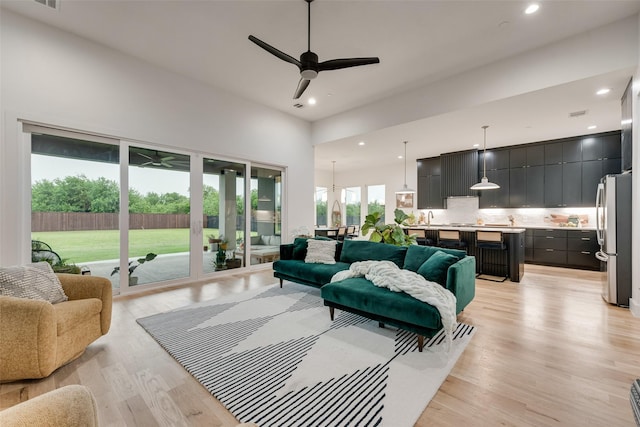living room featuring recessed lighting, ceiling fan, and light wood-style floors