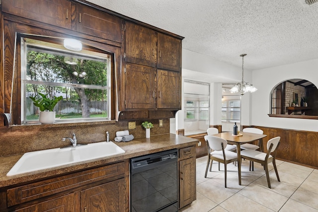 kitchen with dishwasher, a sink, plenty of natural light, a textured ceiling, and light tile patterned flooring