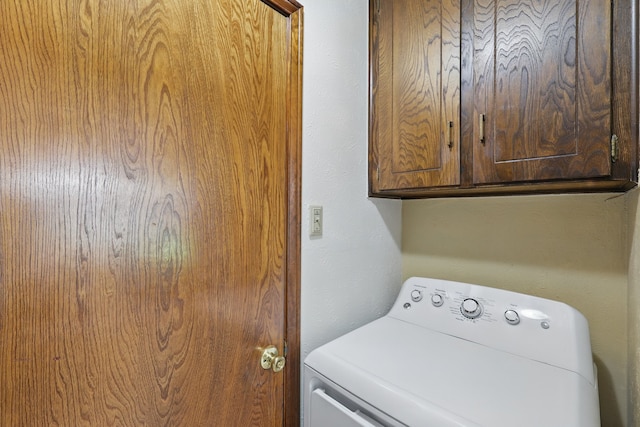 clothes washing area with washer / clothes dryer and cabinet space