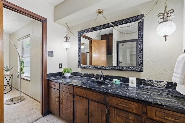 bathroom featuring vanity, a shower with shower door, a textured ceiling, and tile patterned flooring