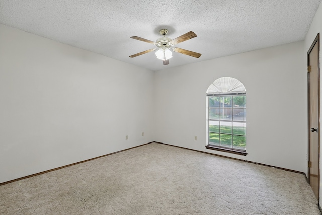 carpeted spare room featuring ceiling fan, a textured ceiling, and baseboards