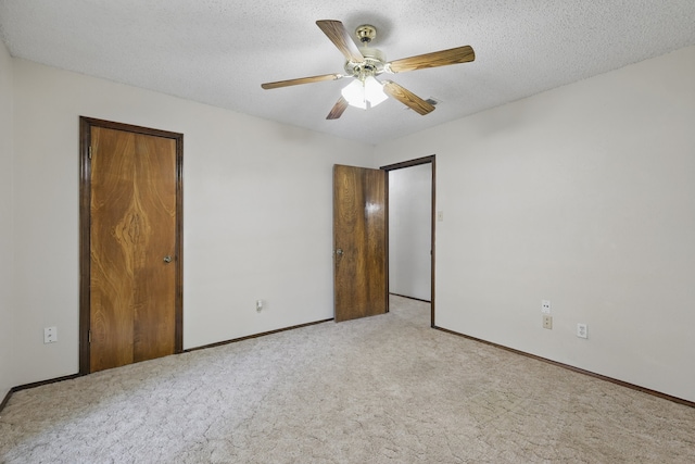 unfurnished bedroom with carpet floors, baseboards, ceiling fan, a closet, and a textured ceiling