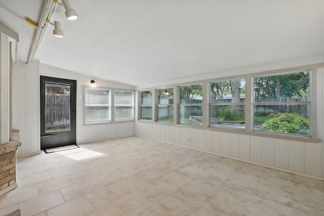 unfurnished sunroom featuring vaulted ceiling