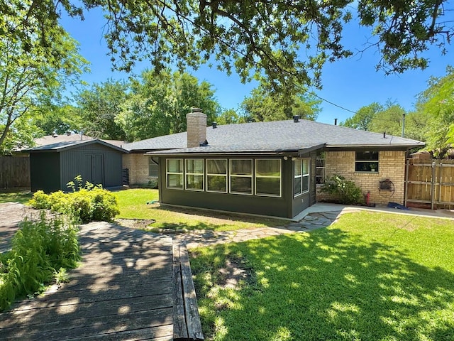 rear view of property with a wooden deck, brick siding, a chimney, and a shingled roof