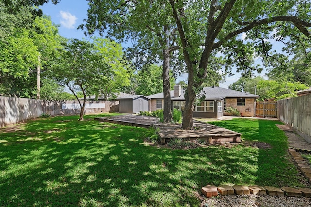 view of yard featuring a storage unit, an outdoor structure, and a wooden deck