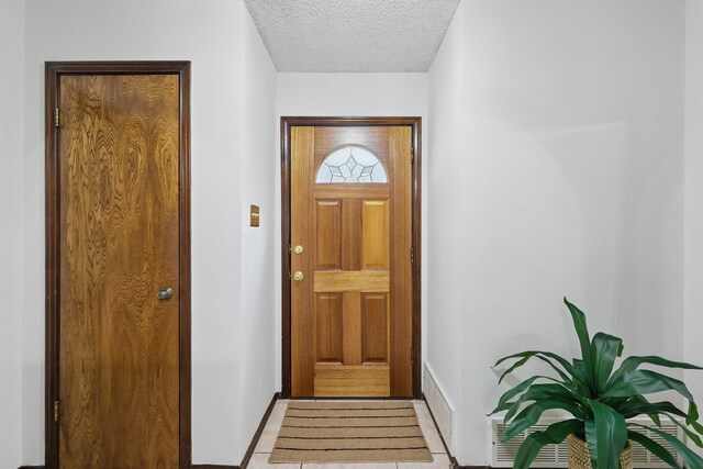 entryway featuring a textured ceiling and baseboards