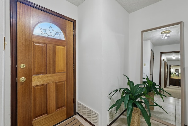 entryway featuring a textured ceiling and light tile patterned floors