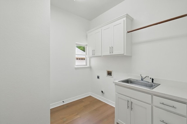 clothes washing area featuring hookup for an electric dryer, washer hookup, cabinet space, light wood-style flooring, and baseboards