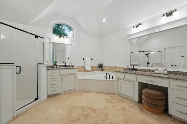 bathroom with vaulted ceiling, a stall shower, a bath, two vanities, and tile patterned flooring