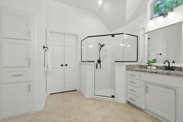 full bath featuring vaulted ceiling, a stall shower, vanity, and tile patterned floors