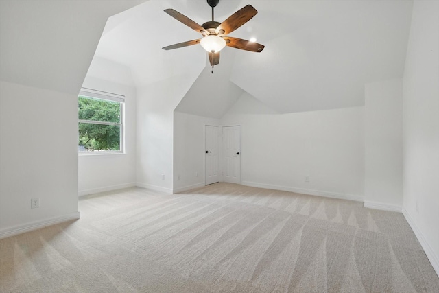 bonus room with vaulted ceiling, light colored carpet, ceiling fan, and baseboards