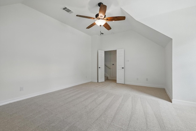 unfurnished bedroom with vaulted ceiling, light colored carpet, baseboards, and ceiling fan
