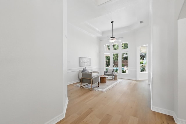 corridor with light wood-type flooring, baseboards, and crown molding