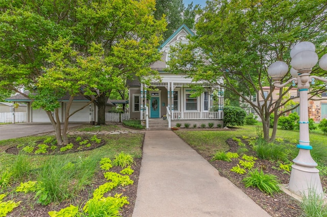 view of front facade featuring a garage, fence, covered porch, and concrete driveway