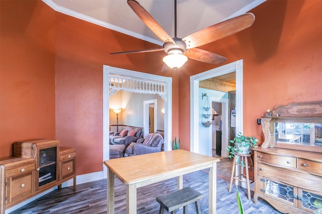dining area with crown molding, dark wood-style flooring, and ceiling fan