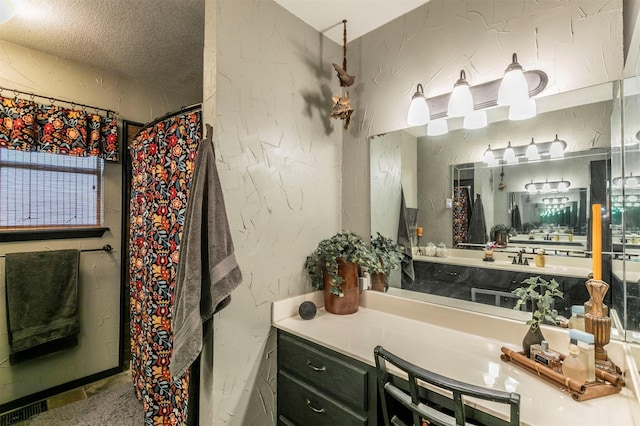 full bathroom featuring vanity, a textured wall, and visible vents