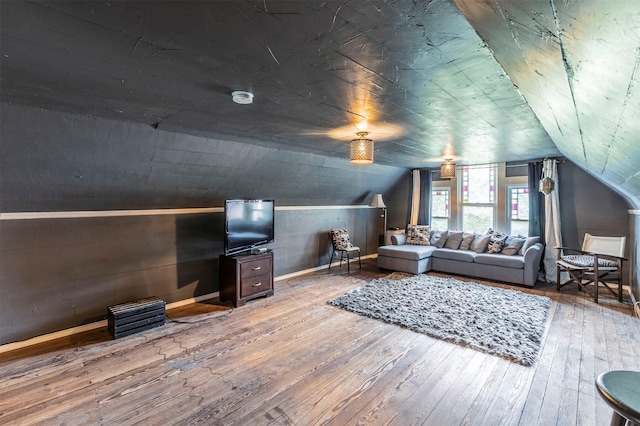living room with baseboards, lofted ceiling, and hardwood / wood-style floors