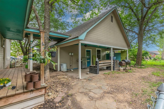 rear view of property with a shingled roof