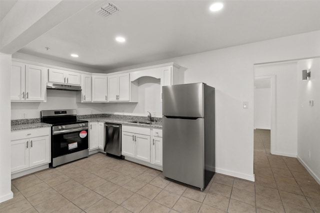 kitchen with light tile patterned floors, under cabinet range hood, white cabinets, and stainless steel appliances