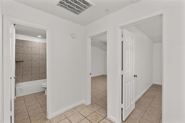 hall featuring light tile patterned flooring, baseboards, and visible vents