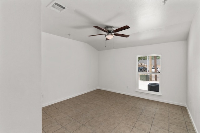 unfurnished room with a ceiling fan, visible vents, vaulted ceiling, baseboards, and light tile patterned flooring