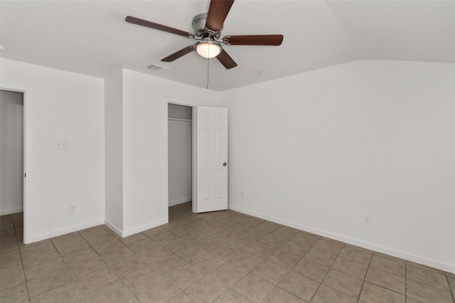 unfurnished bedroom featuring ceiling fan, baseboards, vaulted ceiling, visible vents, and a closet