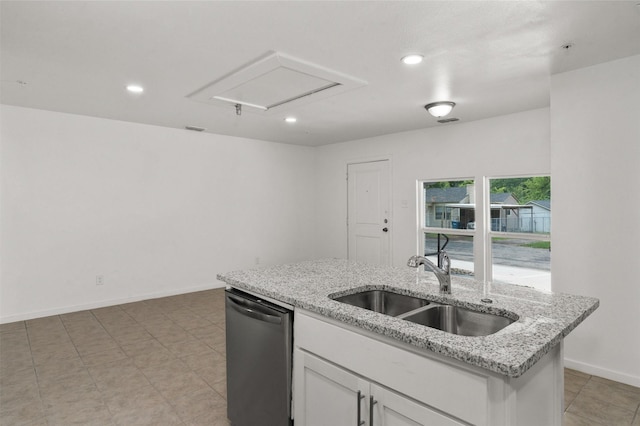 kitchen with stainless steel dishwasher, a center island with sink, white cabinets, light stone counters, and a sink