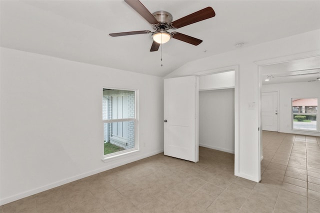 unfurnished bedroom featuring baseboards, a ceiling fan, light tile patterned floors, and vaulted ceiling