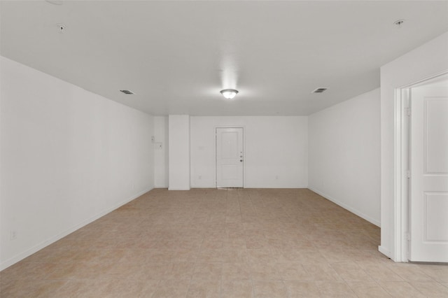 unfurnished room featuring baseboards and visible vents