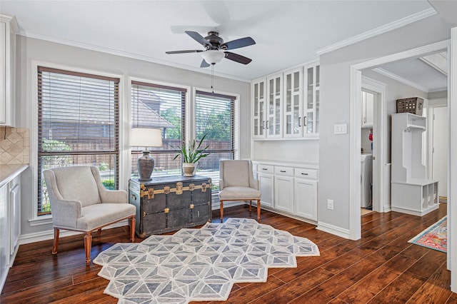 living area with dark wood finished floors, a ceiling fan, crown molding, and baseboards