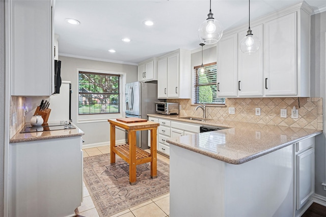 kitchen with a sink, white cabinetry, a peninsula, tasteful backsplash, and light tile patterned floors