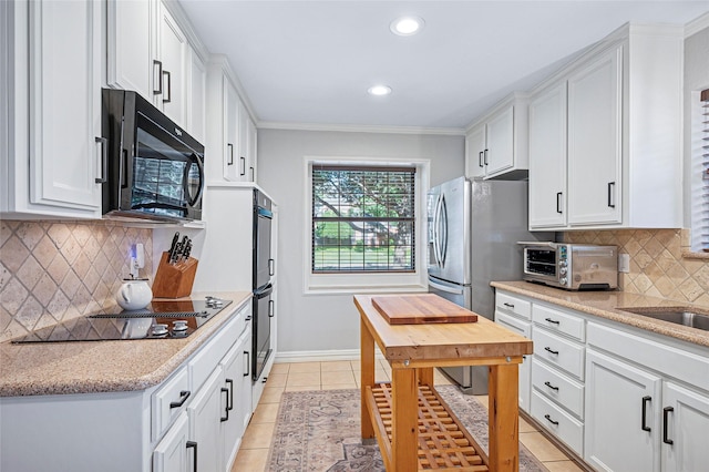 kitchen with black appliances, white cabinetry, baseboards, light tile patterned flooring, and recessed lighting