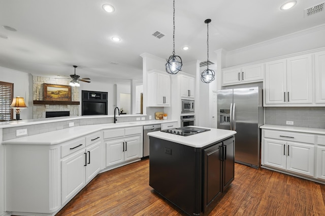 kitchen featuring appliances with stainless steel finishes, ceiling fan, ornamental molding, and visible vents